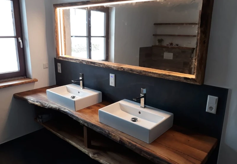 Modernes Badezimmer mit Doppelwaschbecken auf rustikaler Holzplatte und großem Spiegel.